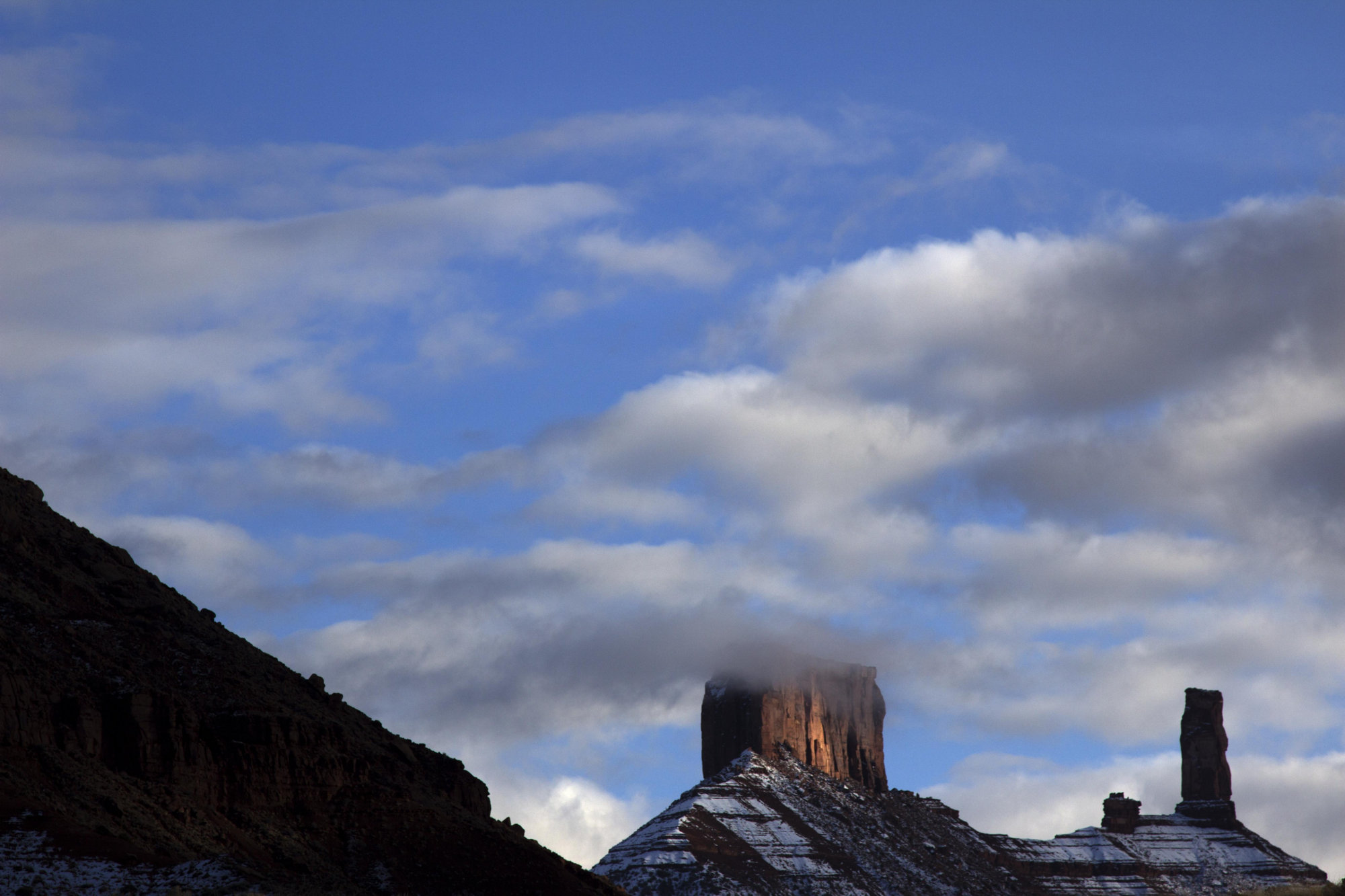 Clouds graze the top of snow-dusted mesas
